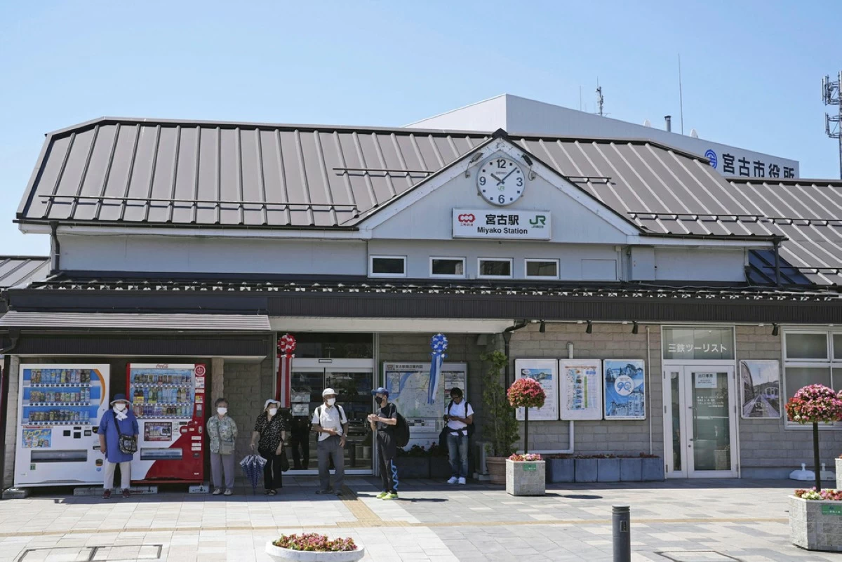 Passengers stand in front of a staion in Miyako, Iwate prefecture, northern Japan Wednesday, July 30, 2025 as train services were suspended due to a tsunami alert following  a powerful earthquake in Russia's Far East. (Yohei Kanesashi/Kyodo News via AP)