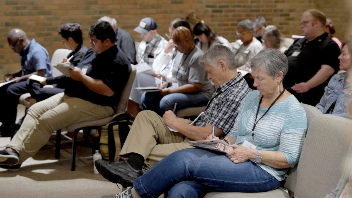 In this image taken from video, participants take notes during a training hosted by Undivided at Central Christian Church in Springfield, Ohio, aimed at teaching community and church leaders how to support and shelter immigrants facing deportation, Tuesday, July 29, 2025. (AP Photo/Obed Lamy)