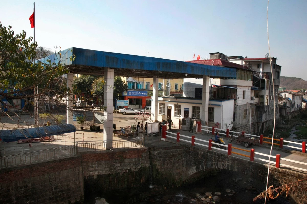 FILE - Chinese security officers stand at a border gate between Kachin rebel-controlled Laiza in Myanmar's north and China's western Yunnan, March 21, 2018. (AP Photo/Esther Htusan, File)