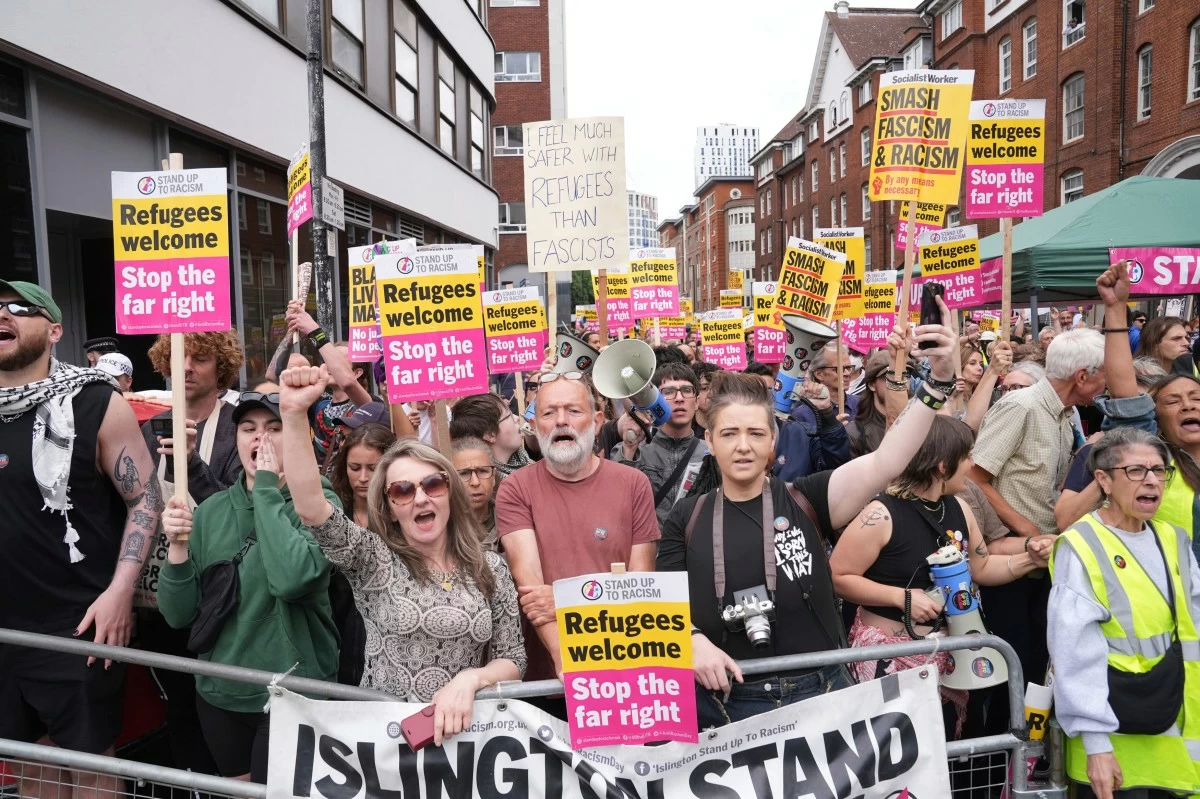 Stand Up To Racism counter protesters gather outside the Thistle City Barbican Hotel in central London, which houses asylum seekers, Saturday Aug. 2, 2025. (PA via AP)