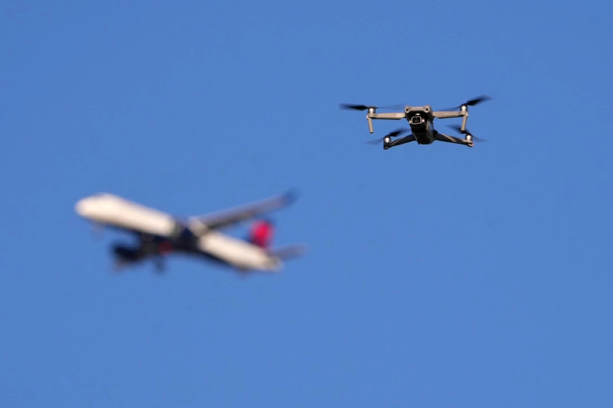 FILE - A drone hovers in airspace outside the safety perimeter surrounding St. Louis Lambert International Airport as an airliner approaches for a landing on March 10, 2025. (AP Photo/Jeff Roberson, File)
