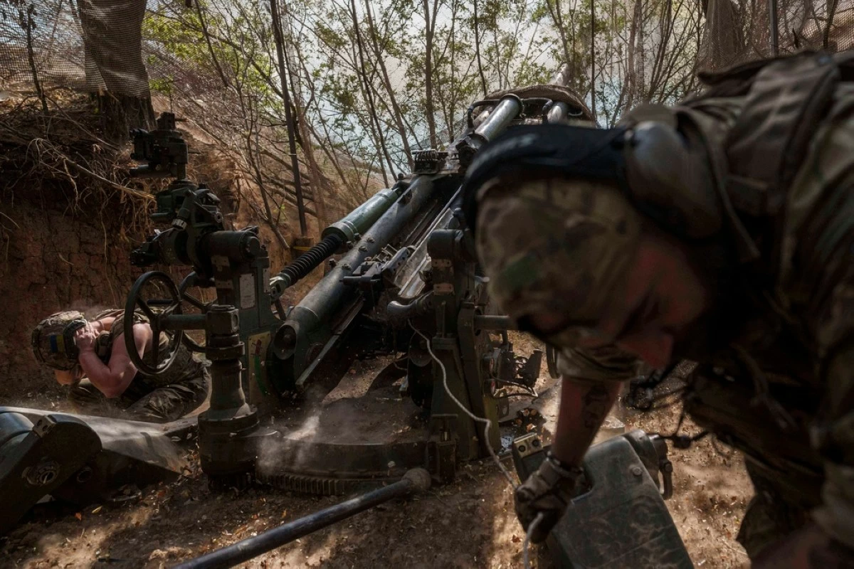 Ukrainian servicemen of the 148th artillery brigade fire from a M777 howitzer towards Russian positions at the frontline in Zaporizhzhia region, Ukraine, on Thursday, Aug. 7, 2025. (AP Photo/Evgeniy Maloletka)