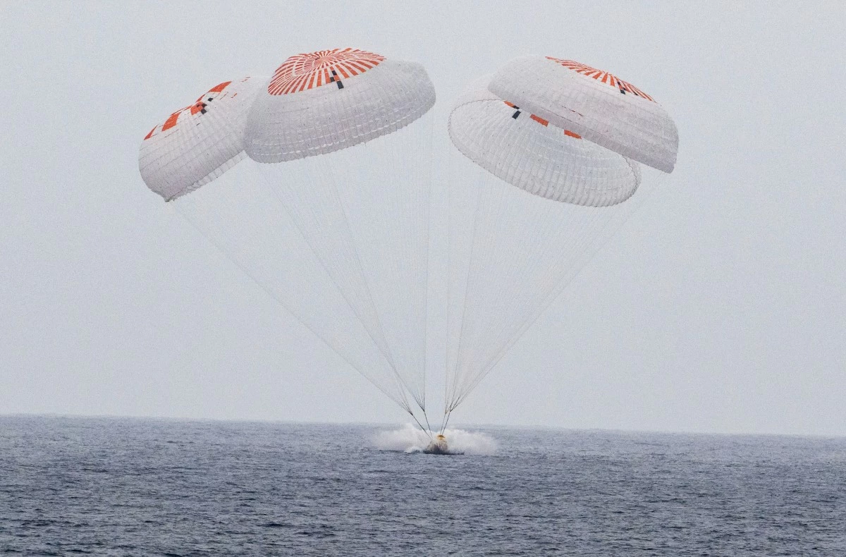 In this image provided by NASA,  SpaceX capsule carrying four astronauts, parachutes into the Pacific Ocean off the Southern California coast on Saturday, Aug. 9, 2025.  (Keegan Barber/NASA via AP)