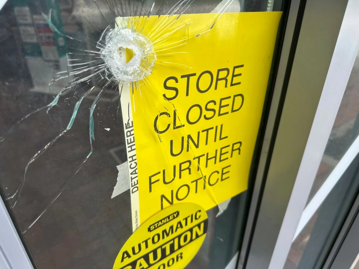 A bullet hole is visible in the door of a CVS pharmacy on Saturday, August 9, 2025,  near where police say a man was shooting at the headquarters of the U.S. Centers for Disease Control and Prevention in Atlanta. (AP Photo/Jeff Amy)