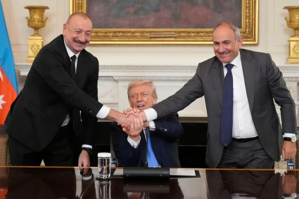 President Donald Trump, center, shakes hands with Armenian Prime Minister Nikol Pashinyan, right, and Azerbaijan President Ilham Aliyev during a trilateral signing ceremony in the State Dining Room of the White House, Friday, Aug. 8, 2025, in Washington. (AP Photo/Mark Schiefelbein)