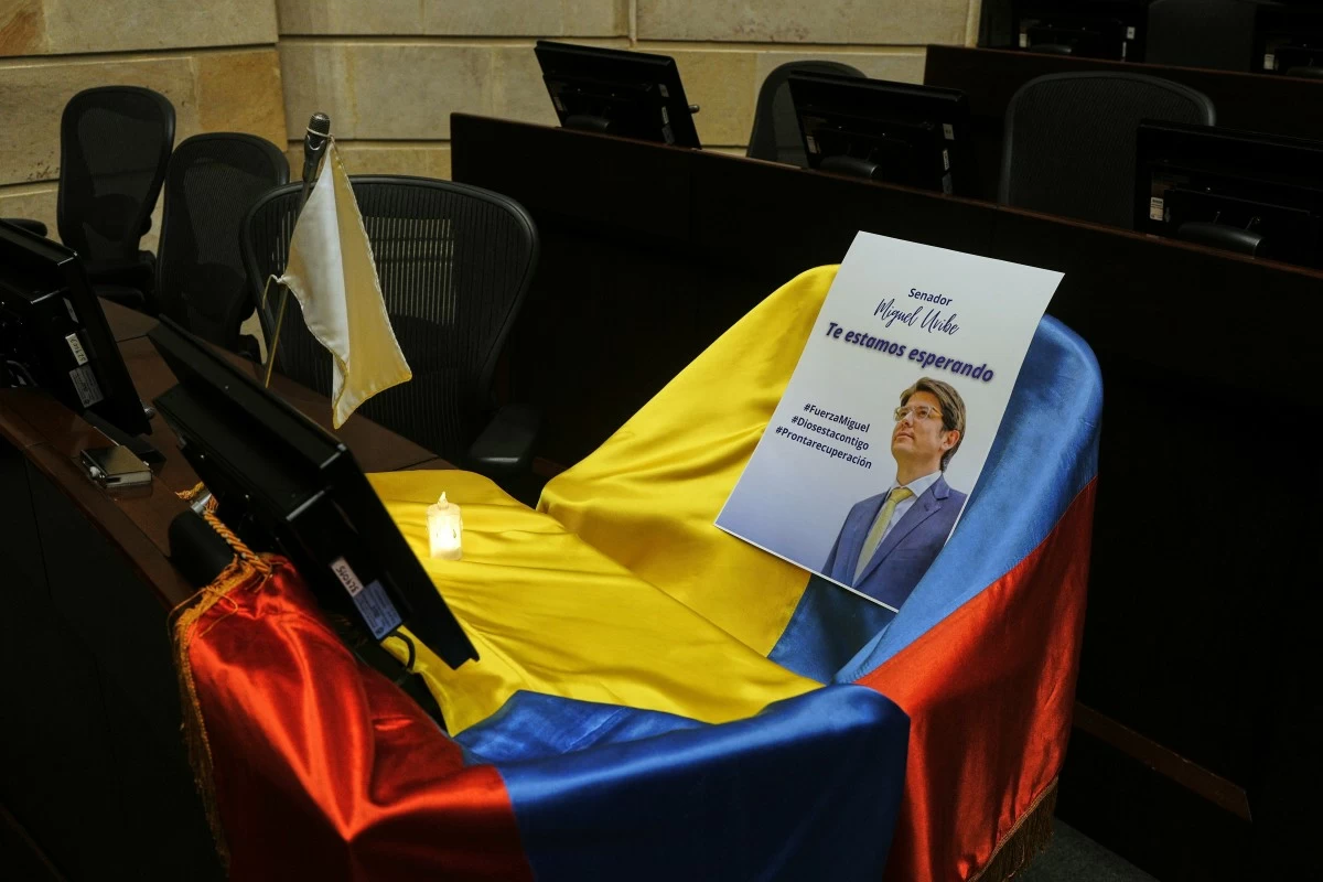 FILE - A leaflet showing Colombian Sen. Miguel Uribe Turbay sits on a Colombian national flag draped over his seat in the congressional chamber in Bogota, Colombia, June 9, 2025. (AP Photo/Ivan Valencia, File)