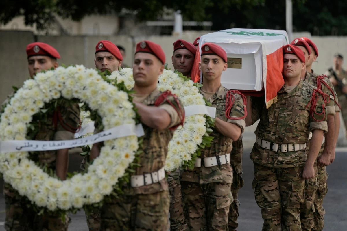 Lebanese army soldiers carry the coffin of Mohammad Shuqair, wrapped in the national flag, during his funeral procession at the Lebanese Military Hospital in Beirut, Lebanon, Sunday, Aug. 10, 2025. (AP Photo/Bilal Hussein)