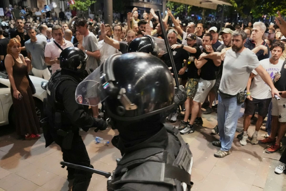 Serbian gendarmerie officers separate protesters from opposing camps during an anti-government protest in Belgrade, Serbia, Wednesday, Aug. 13, 2025. (AP Photo/Darko Vojinovic)