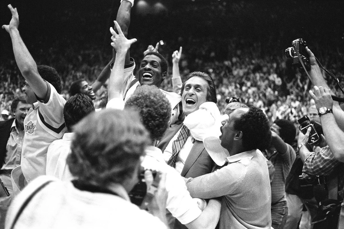 FILE - Los Angeles Lakers head coach Pat Riley, center right, is swamped by fans and players after the Lakers defeated the Philadelphia 76ers to win the NBA championship in Los Angeles, June 9, 1982. (AP Photo/Lennox McLendon, File)
