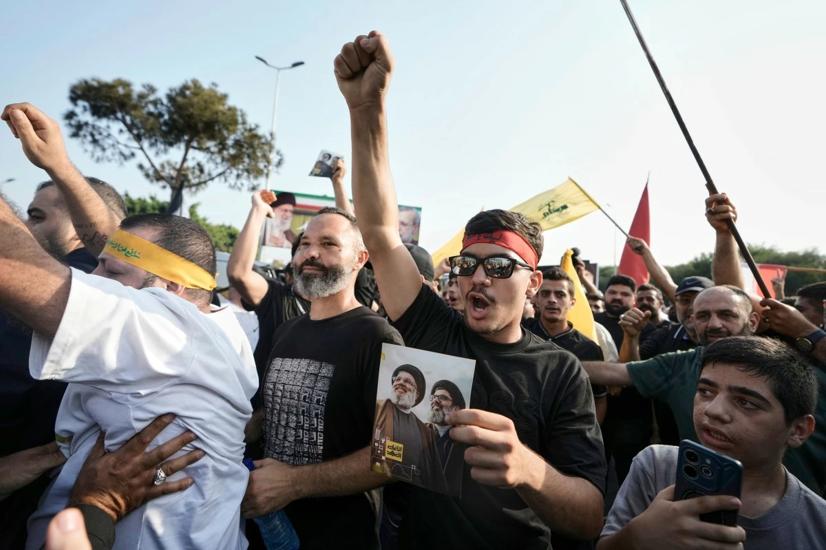 Hezbollah supporters chant slogans as they gather to welcome Ali Larijani, head of Iran's National Security Council, outside Rafik Hariri International Airport in Beirut, Lebanon, Wednesday, Aug. 13, 2025. (AP Photo/Bilal Hussein)