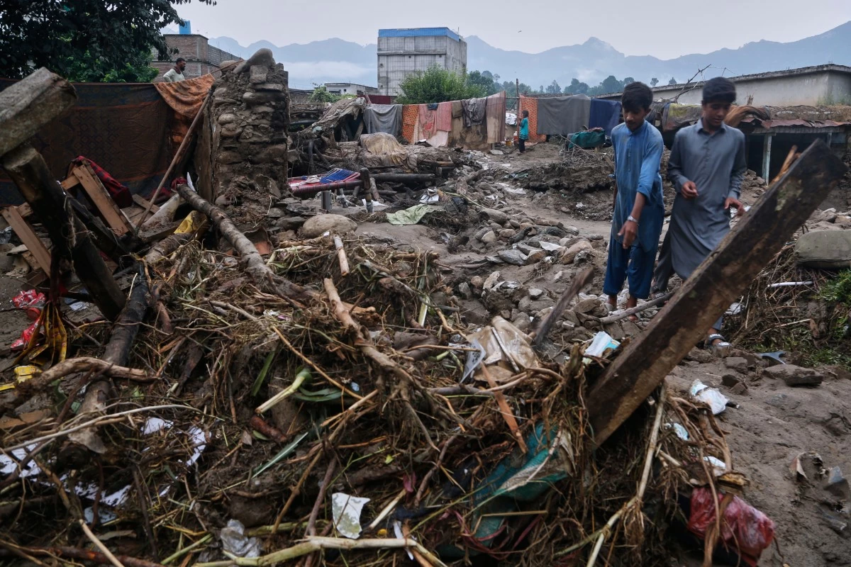 Villagers collect usable items through the rubble of their partially damaged home following Friday's flash flooding at a neighbourhood of Pir Baba, an area of Buner district, in Pakistan's northwest, Sunday, Aug. 17, 2025. (AP Photo/Muhammad Sajjad)