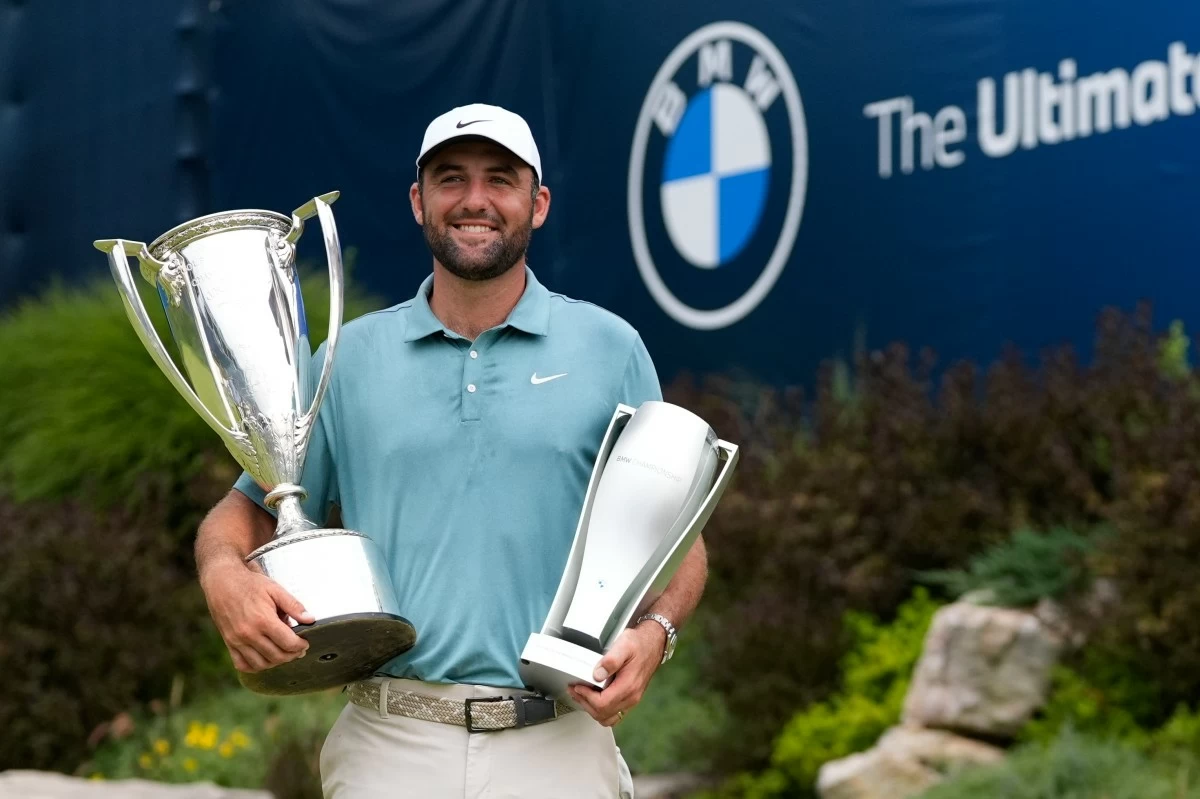Scottie Scheffler poses with the trophies after winning the BMW Championship golf tournament Sunday, Aug. 17, 2025, in Owings Mills, Md. (AP Photo/Stephanie Scarbrough)