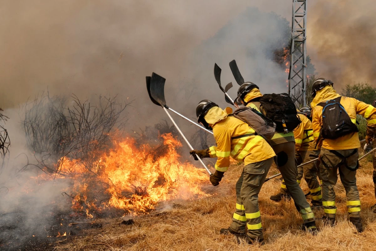 Firefighters battle a wildfire in Veiga das Meas, northwestern Spain, Saturday, Aug. 16, 2025. (AP Photo/Lalo R. Villar)