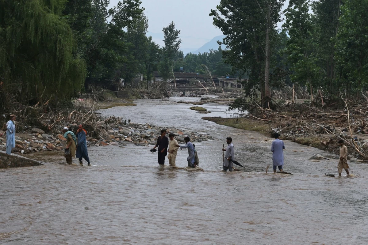 Local residents cross a stream following Friday's flash flooding hit area in Pishoreen village in Buner district, in Pakistan's northwest, Sunday, Aug. 17, 2025. (AP Photo/Muhammad Sajjad)