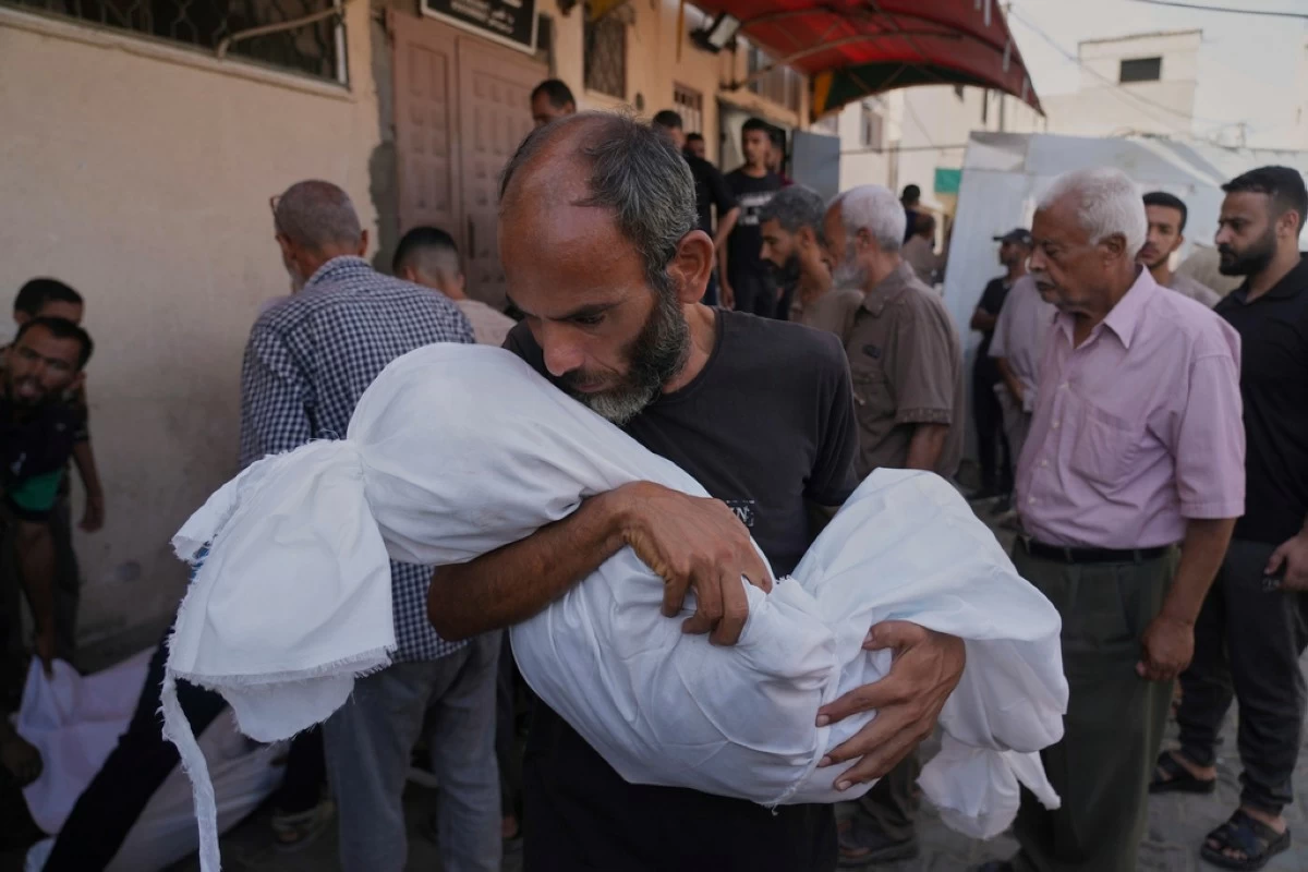 Ahmed Al-Hajj carries the body of his daughter, Dana Al-Hajj, 13, who was killed in an Israeli airstrike in the Gaza Strip, at Al-Aqsa Hospital in Deir al-Balah, Tuesday, Aug. 19, 2025. (AP Photo/Abdel Kareem Hana)