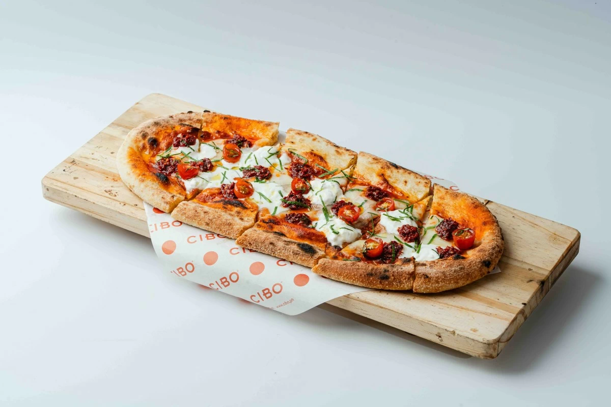 SPICY INDULGENCE Cibo’s Nduja Pizza, topped with spicy sausage, tomato sauce, mozzarella, and creamy burrata, is part of the Italian restaurant’s 28th anniversary limited-edition menu available until Sept. 30.