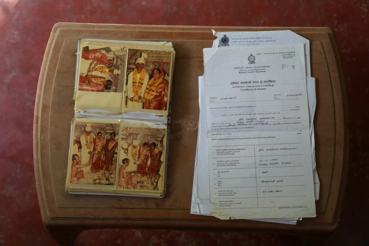 Wedding photos of Sri Lankan ethnic Tamils Sanmugam Satkunarasa and Ranjanidevi are placed next to a certificate issued by the government declaring the husband missing, at their home in Manippai, Sri Lanka, Aug. 6, 2025. (AP Photo/Eranga Jayawardena)