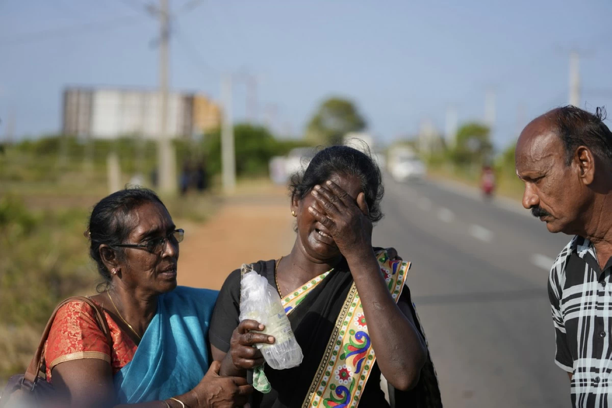 Senthilvel Sothiladchumi, an ethnic Sri Lankan Tamil, center, whose son went missing during the Sri Lankan civil war, cries as she leaves the site of a mass grave where authorities exhibited unearthed belongings in an effort to secure the identities of the victims, in Chemmani, Sri Lanka, Aug. 5, 2025. (AP Photo/Eranga Jayawardena)