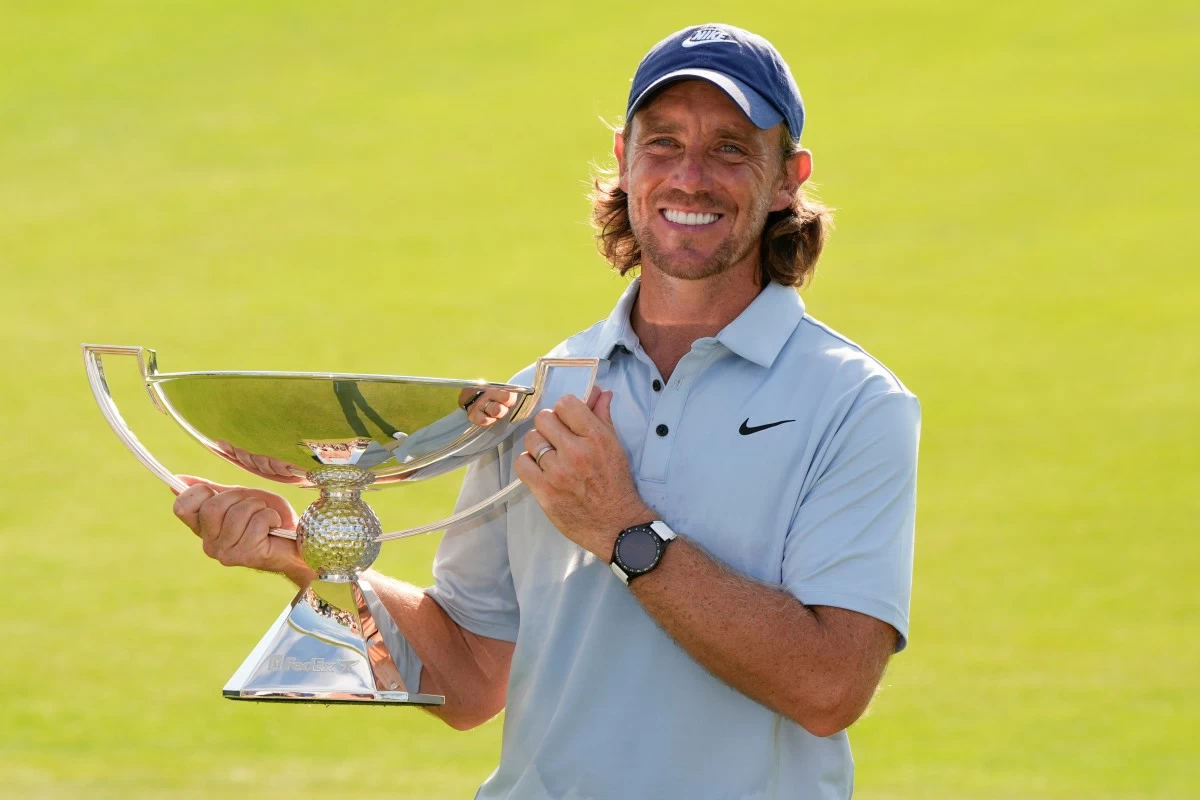 Tommy Fleetwood, of England, holds the championship trophy after the final round of the Tour Championship golf tournament, Sunday, Aug. 24, 2025, in Atlanta. (AP Photo/Mike Stewart)