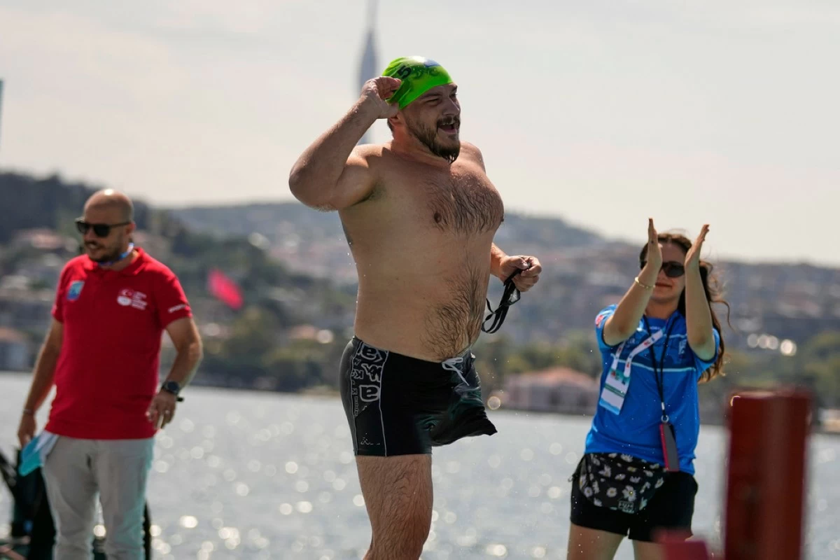 Ukrainian war veteran Oleksandr Dashko crosses the finish line during a 6.5km swimming race across the Bosporus Strait, from the Asian side to the European side, in Istanbul, Turkey, Sunday, Aug. 24, 2025. (AP Photo/Khalil Hamra)