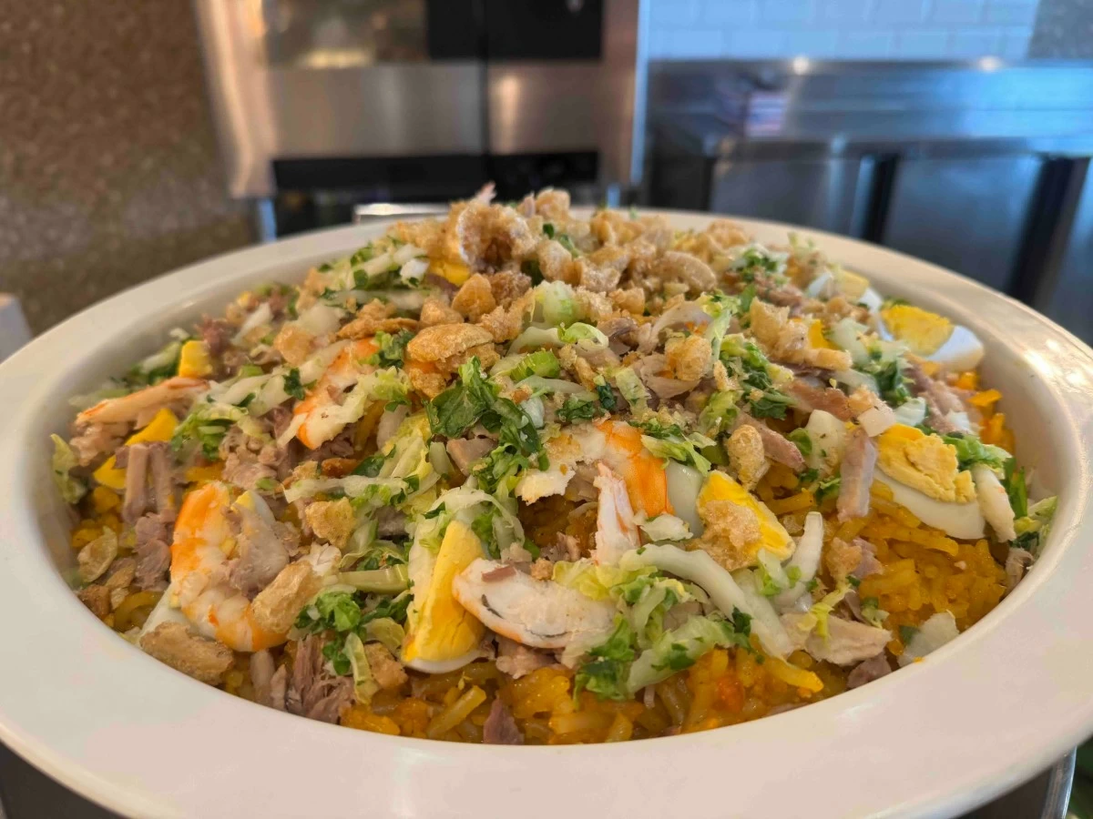 GOLDEN THREADS Pancit Malabon takes center stage with its rich seafood flavors and vibrant toppings, a noodle dish that captures the heart of every Filipino feast.