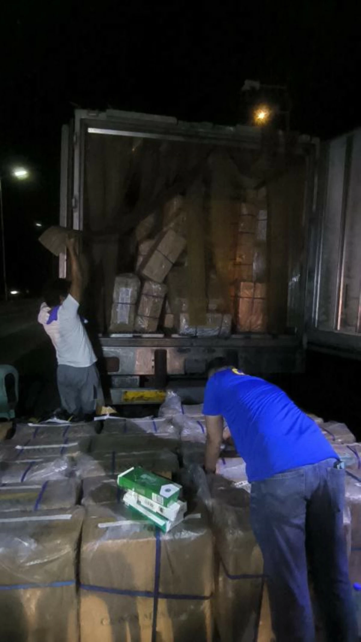A CIDG operative inspects the confiscated cigarettes during an operation in Davao del Sur on Aug. 25, 2025 (photo: CIDG)