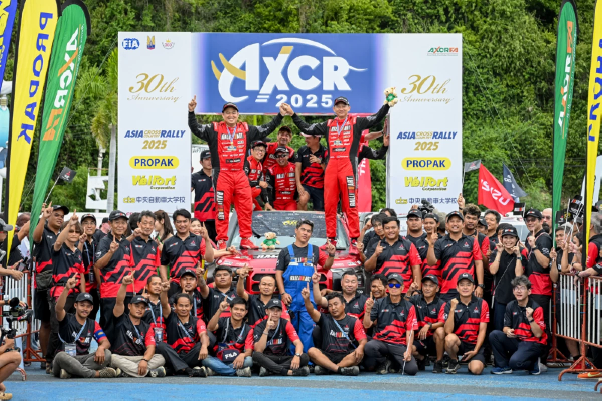 Lead Mitsubishi driver Chayapon Yotha and co-driver Peerapong Sombutwong (standing on roof) celebrate their win with the Mitsubishi Ralliart team.