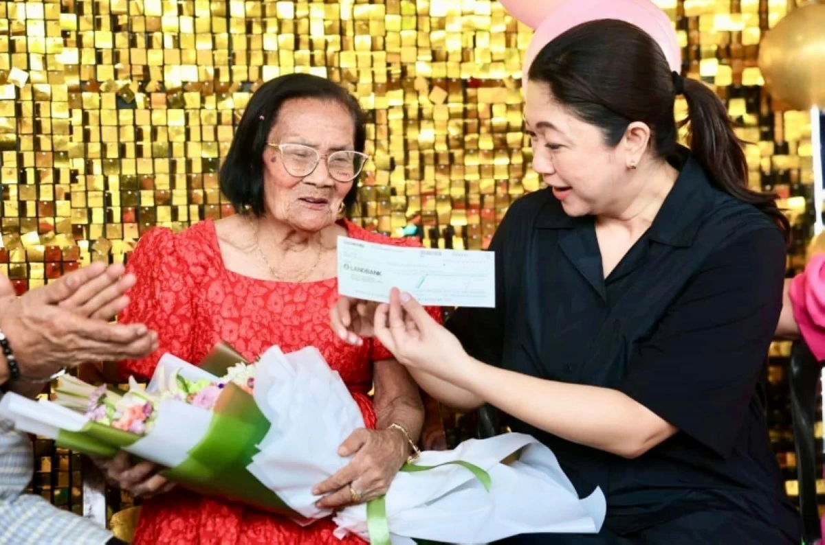 Taguig Mayor Lani Cayetano (right) gives the P100,000 check to centenarian Victoria Almazan (Photo from Mayor Cayetano's Facebook account) 