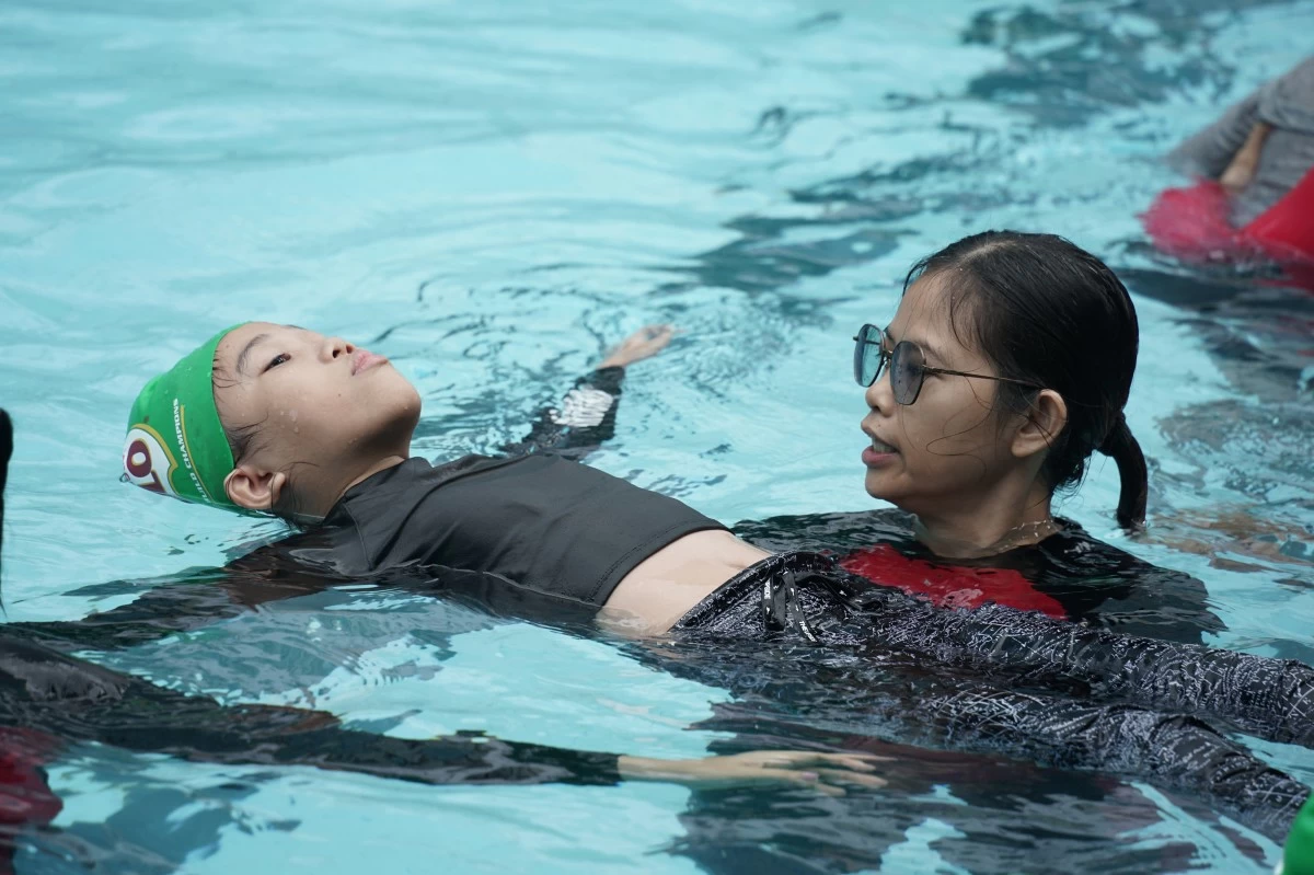 IN PHOTO: MILO® SAFE Swim participant practicing water safety techniques and Philippine Red Cross conducting CPR training for MILO® SAFE Swim participants
