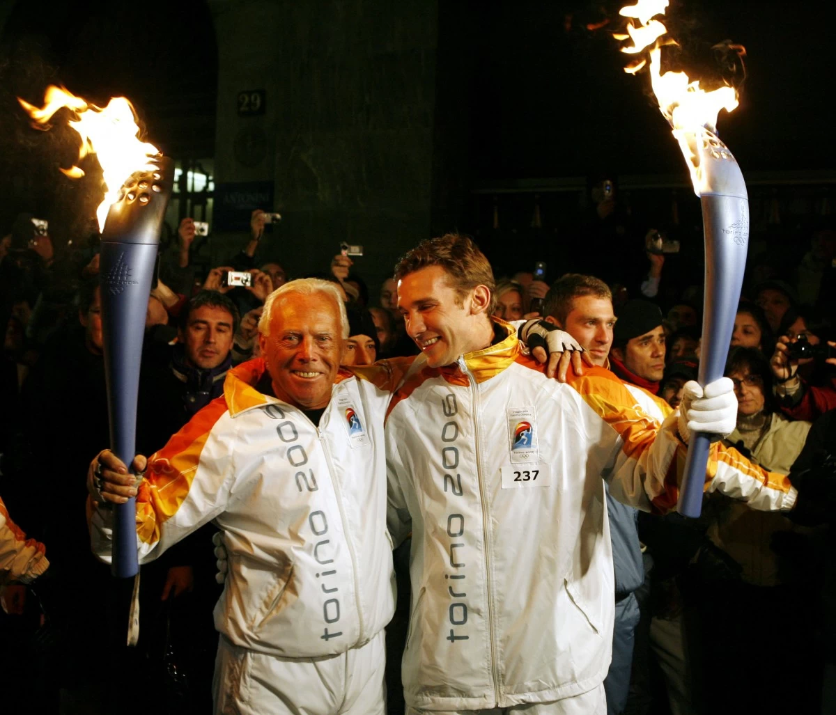 FILE - Italy's fashion designer Giorgio Armani, left, and AC Milan's soccer player Andriy Shevchenko of Ukraine, pose for a photo holding the Olympic torches in Milan, northern Italy, Jan. 29, 2006. (AP Photo/Luca Bruno, File)