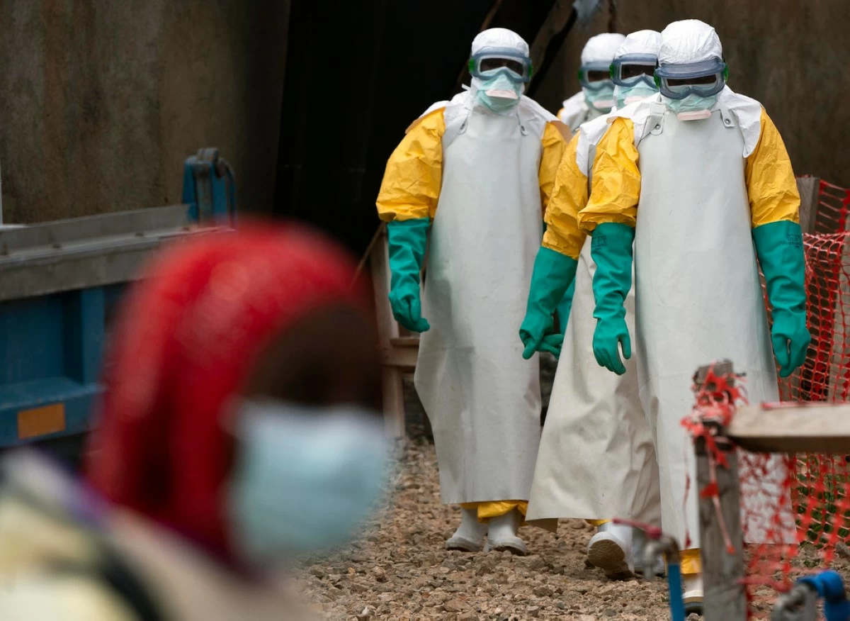 FILE - Health workers dressed in protective gear begin their shift at an Ebola treatment center in Beni, Congo DRC, Tuesday, July 16, 2019. (AP Photo/Jerome Delay, File)