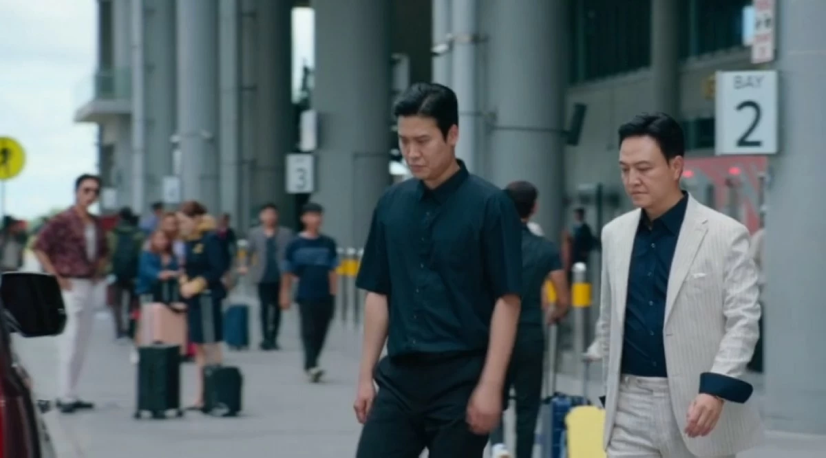  Korean actor Jung Woong-in (right) with Joo Jong-Hyuk and Park Min-young in the background at the Ninoy Aquino International Airport Terminal 3 in a scene in 