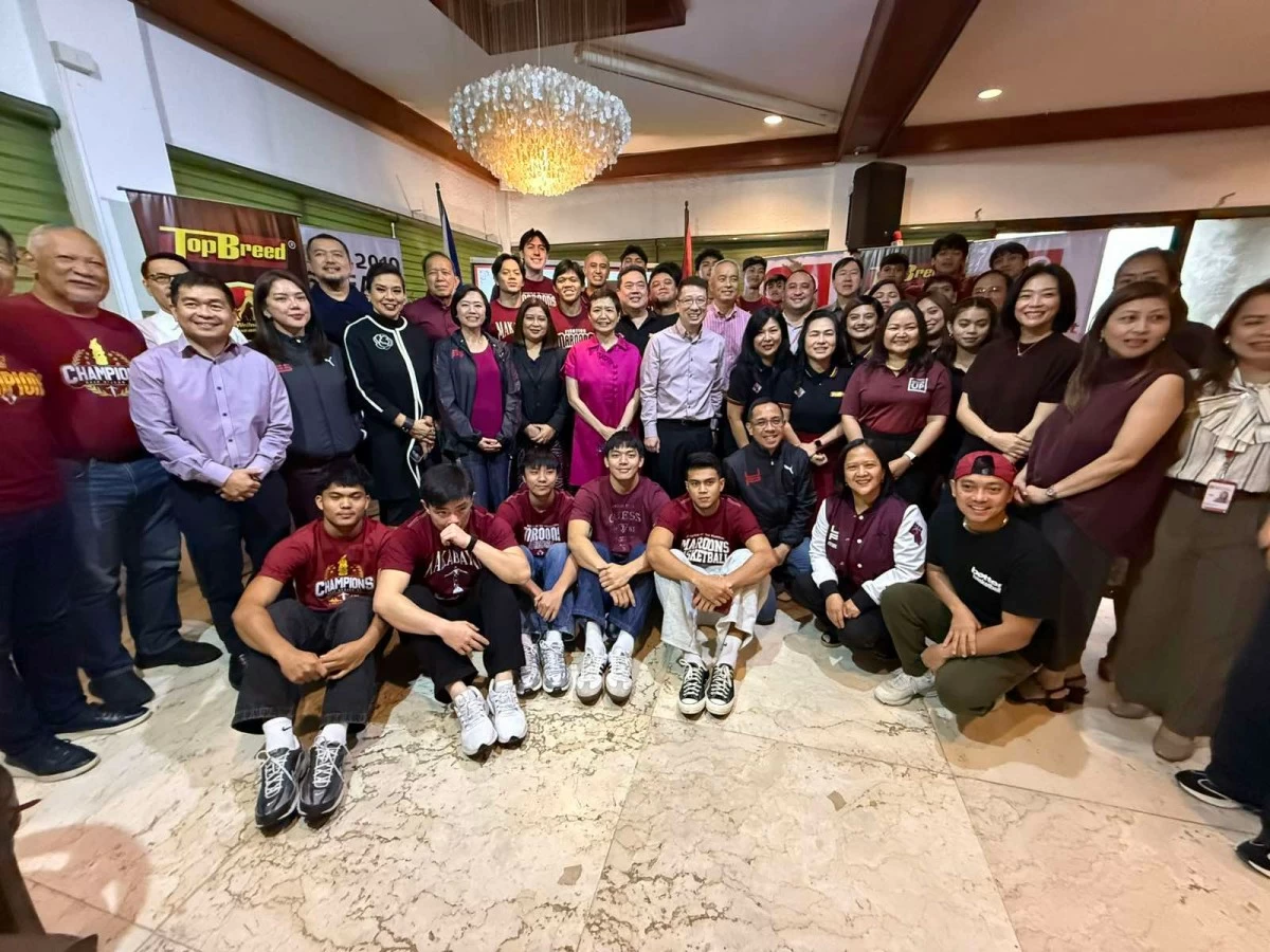 Robinsons Retail chairman Robina Gokongwei-Pe (center) along with the players and team officials of the UP Fighting Maroons. (Roberto Coloma)
