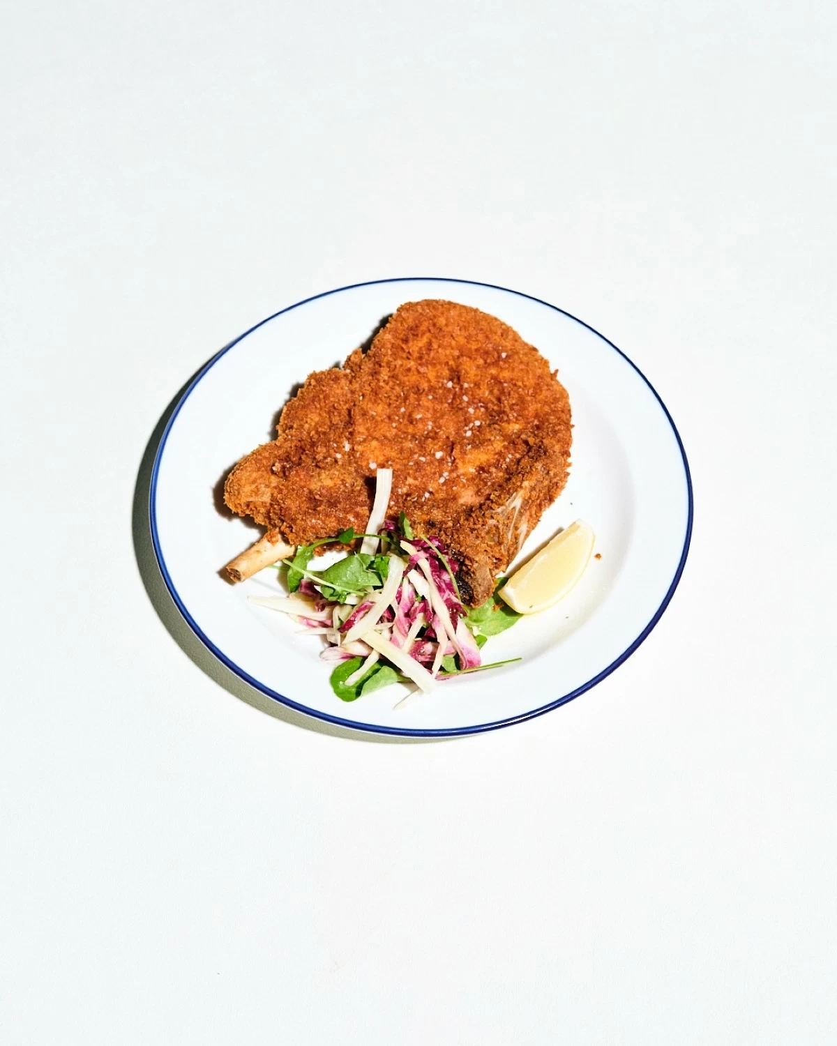 GOLDEN CRUNCH Breaded Pork Cotoletta, crisp on the outside and tender within, a hearty take on a classic Italian favorite.