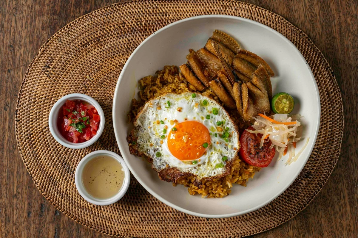 CRISP TRADITION Day-old Hahay brings cured local needlefish together with crab fat rice and a fried egg.