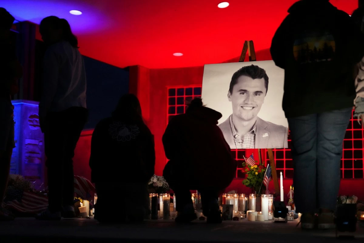 People place lit candles below a photo of Charlie Kirk, the CEO and co-founder of Turning Point USA who was shot and killed, at a vigil in his memory, Thursday, Sept. 11, 2025, in Orem, Utah. (AP Photo/Lindsey Wasson)