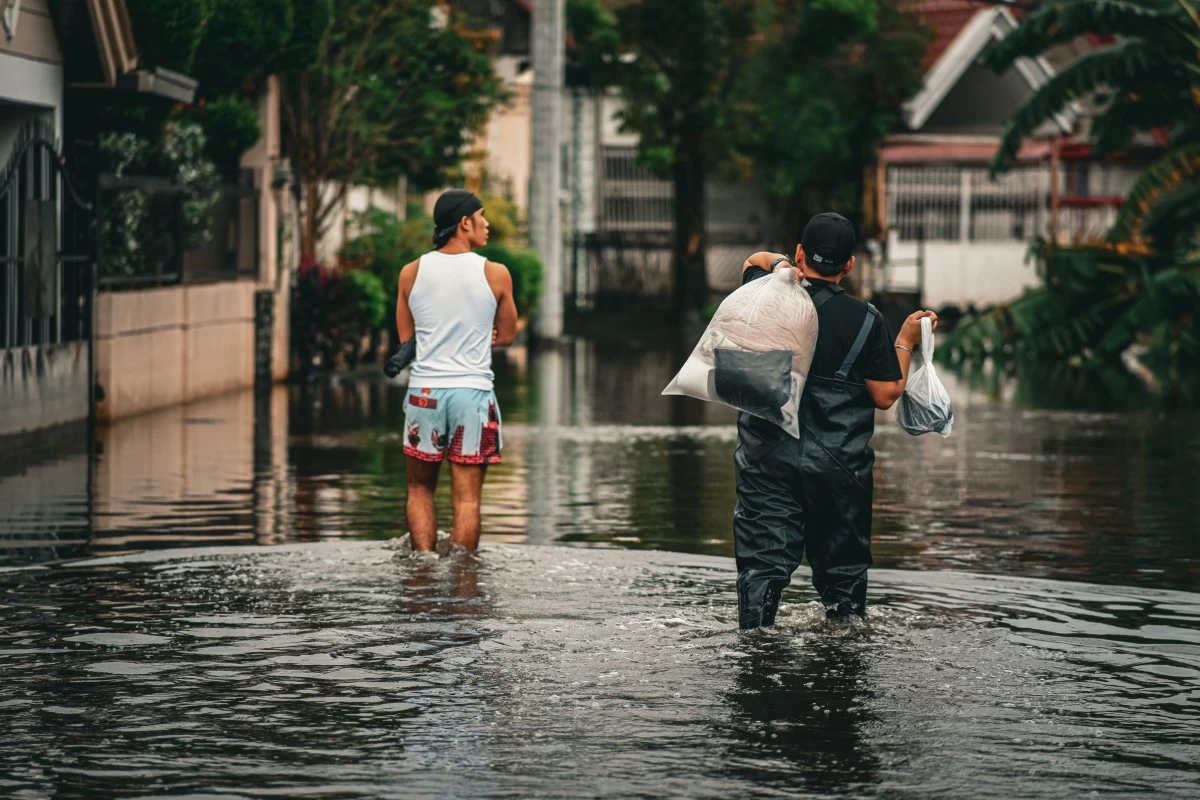  Two residents of Marilao, Bulacan traverse the flooded streets of their town last July 25, 2025. Shutterstock/Cherish Gonzales

