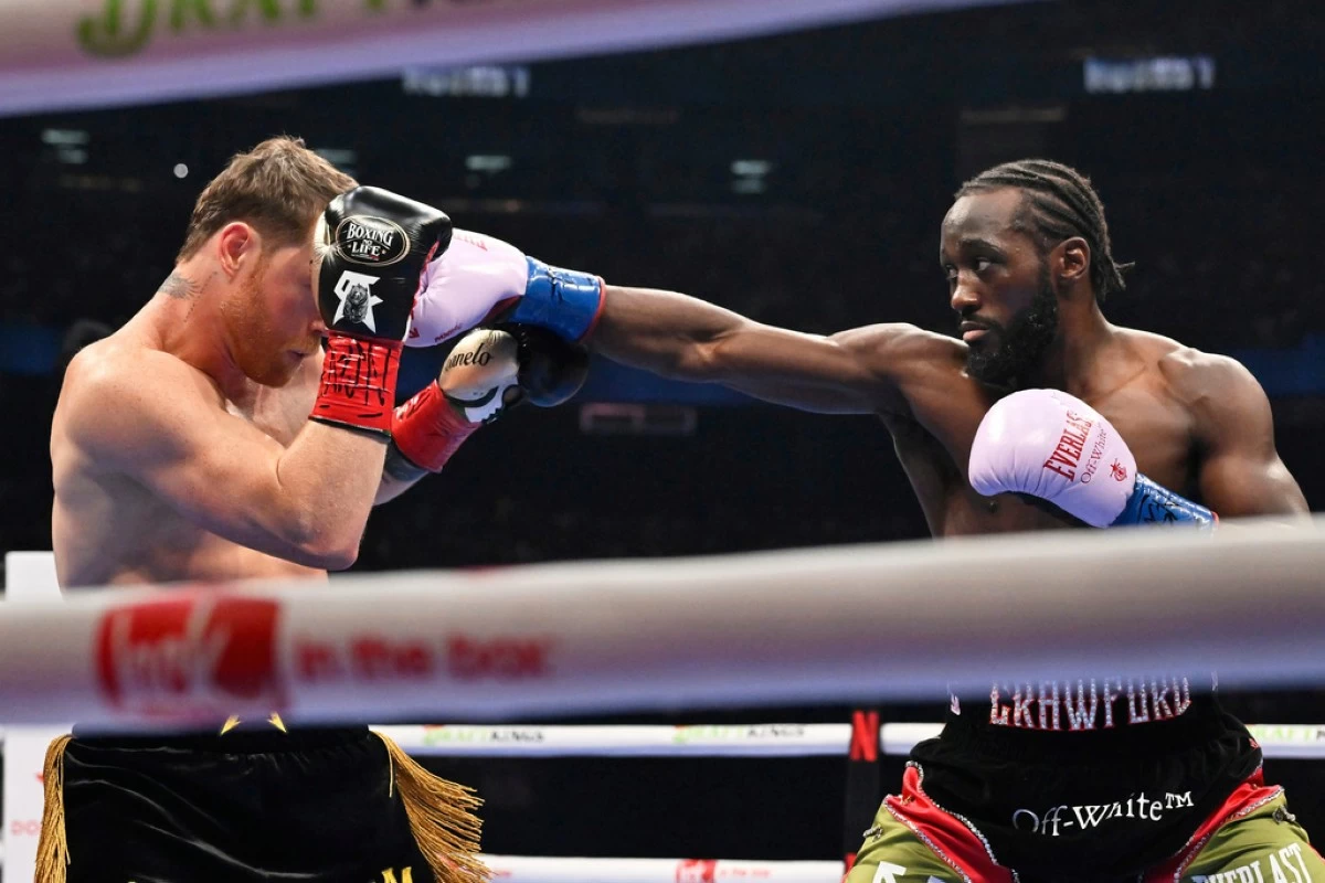 Terence Crawford, right, throws a punch at Canelo Alvarez during an undisputed super middleweight championship boxing match in Las Vegas, Saturday, Sept. 13, 2025. (AP Photo/David Becker)