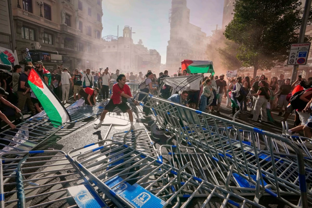 Protesters block the road in an attempt to disrupt the twenty-first stage of the Spanish cycling race La Vuelta, from Alalpardo to Madrid, Spain, Sunday, Sept. 14, 2025. (AP Photo/Manu Fernández)