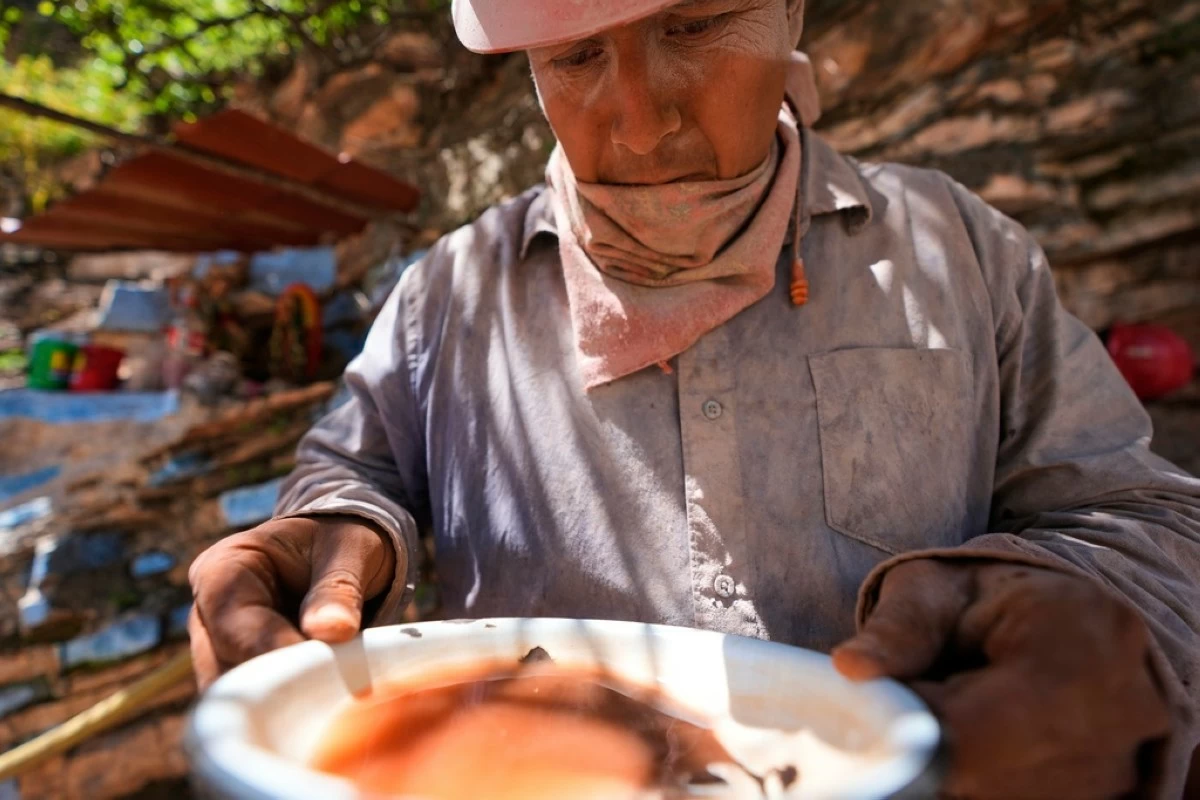 Hugo Flores analyzes a sample of sand and rocks to determine the amount of mercury ore before cooking it in San Joaquin, Mexico, Tuesday, Aug. 19, 2025. (AP Photo/Fernando Llano)