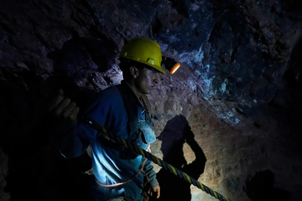 A worker holds a rope that his colleagues use to climb out of one of the caverns while mining for mercury in San Joaquin, Mexico, Tuesday, Aug. 19, 2025. (AP Photo/Fernando Llano)