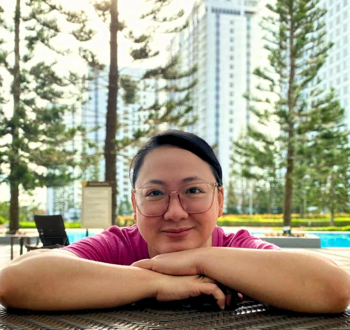 With the scenic backdrop of pine trees and the towers of Wind Residences, Arch.. Pam de Guzman enjoys a quiet moment by the pool in Tagaytay.