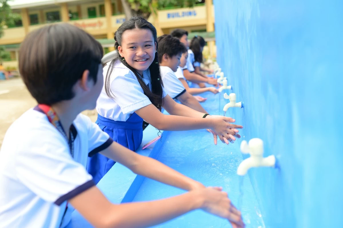 PUPILS wash their hands in a handwashing facility in the school.