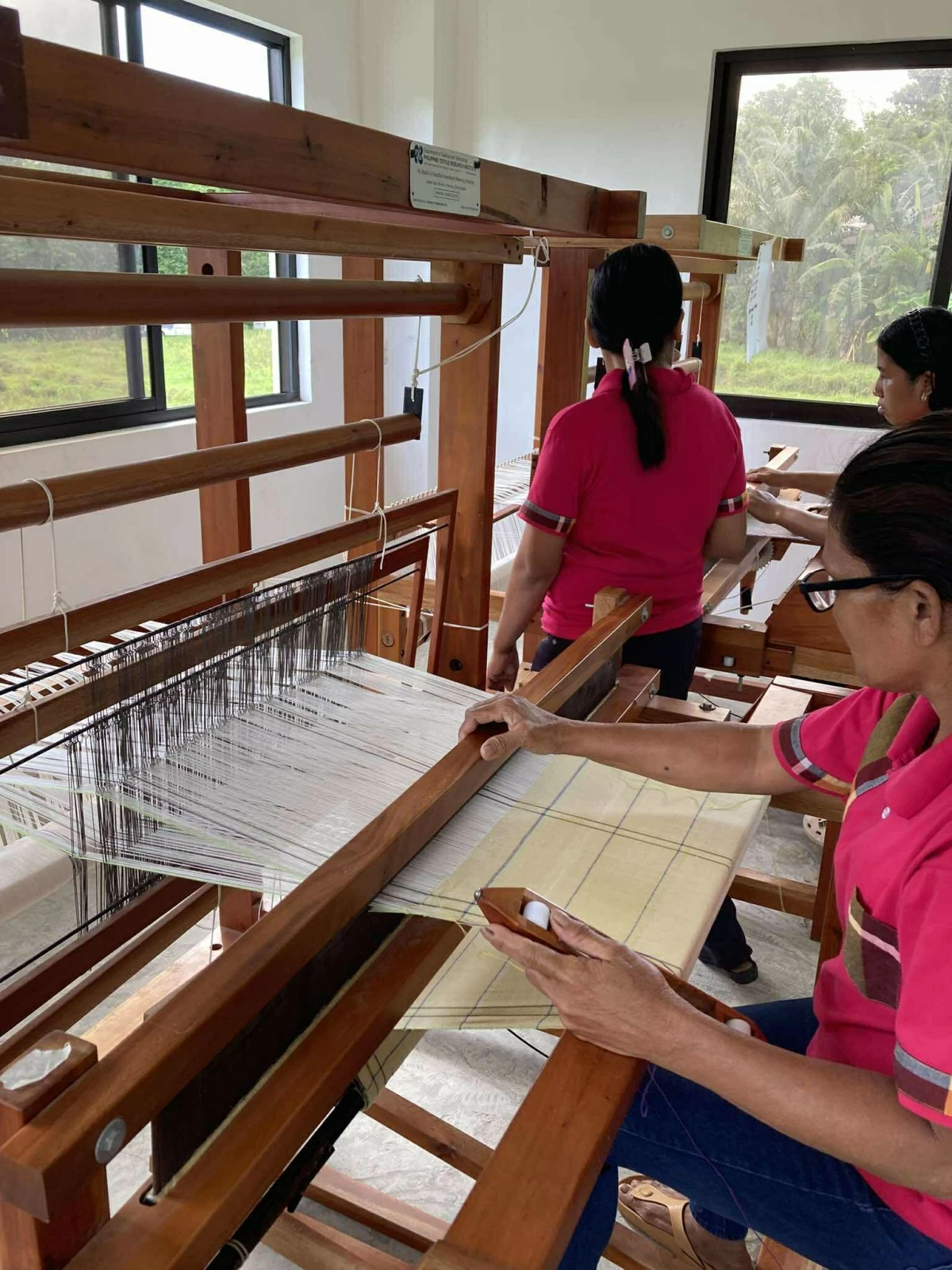 ARTISANS AT WORK Weavers demonstrate how to use the traditional weaving devices.