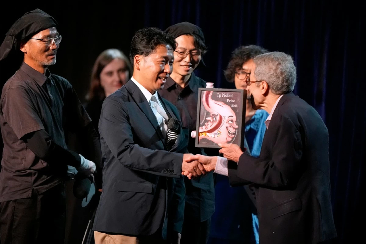 The Ig Nobel Prize for biology is accepted by Tomoki Kojima, Kazato Oishi, Yasushi Matsubara, Yuki Uchiyama, Yoshihiko Fukushima, Naoto Aoki, Say Sato, Tatsuaki Masuda, Junichi Ueda, Hiroyuki Hirooka, and Katsutoshi Kino, for their experiments to learn whether cows painted with zebra- like striping can avoid being bitten by flies, Thursday, Sept. 18, 2025, in Boston. (AP Photo/Robert F. Bukaty)