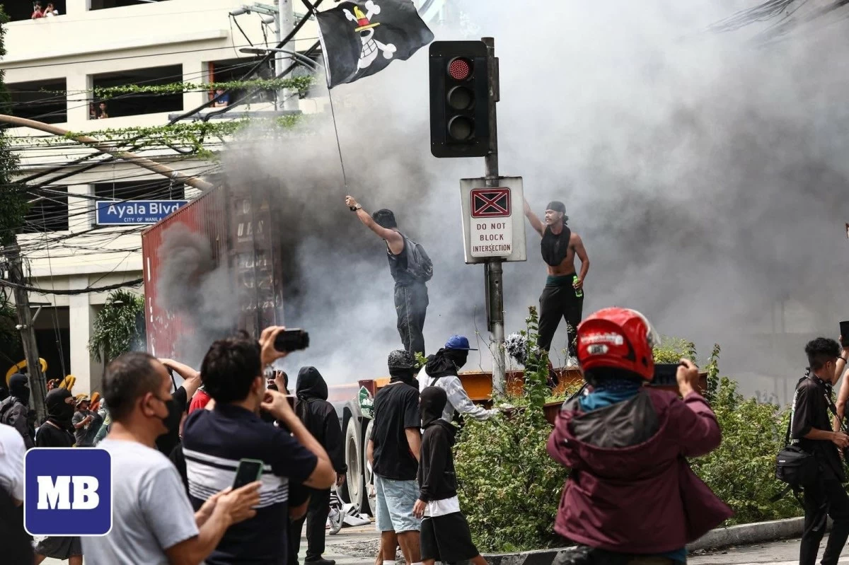 Protesters throw rocks and burn a ten-wheeler truck at Ayala Bridge on Sunday, September 21. They called for accountability over alleged corruption involving government officials. (Photos by John Louie Abrina/MB)