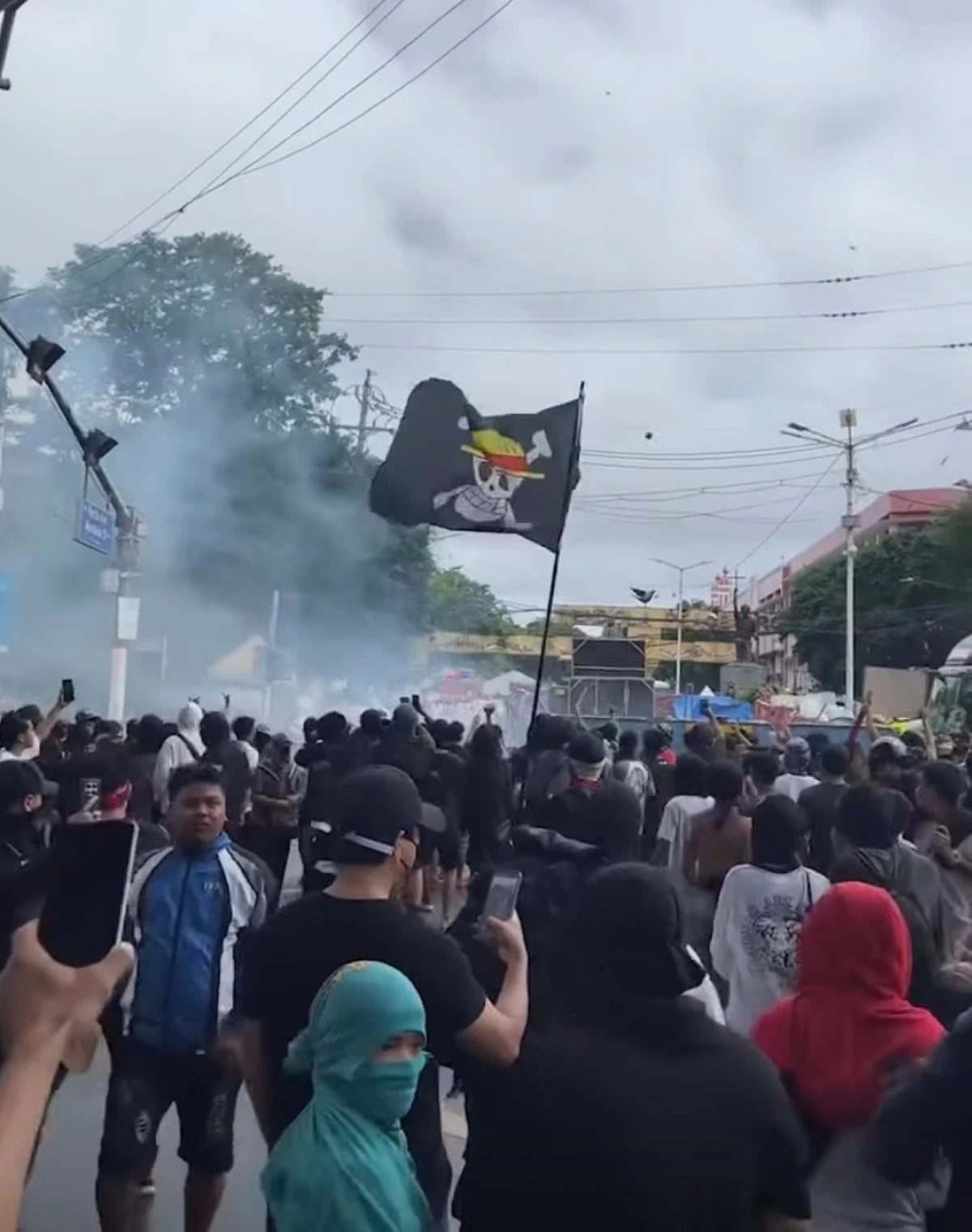 Protesters wave the Straw Hat Pirates insignia from the anime One Piece as they throw rocks and other debris at the police phalanx in Mendiola, Manila on Sunday, Sept. 21. (Photo from Owen Barce Padernilla)