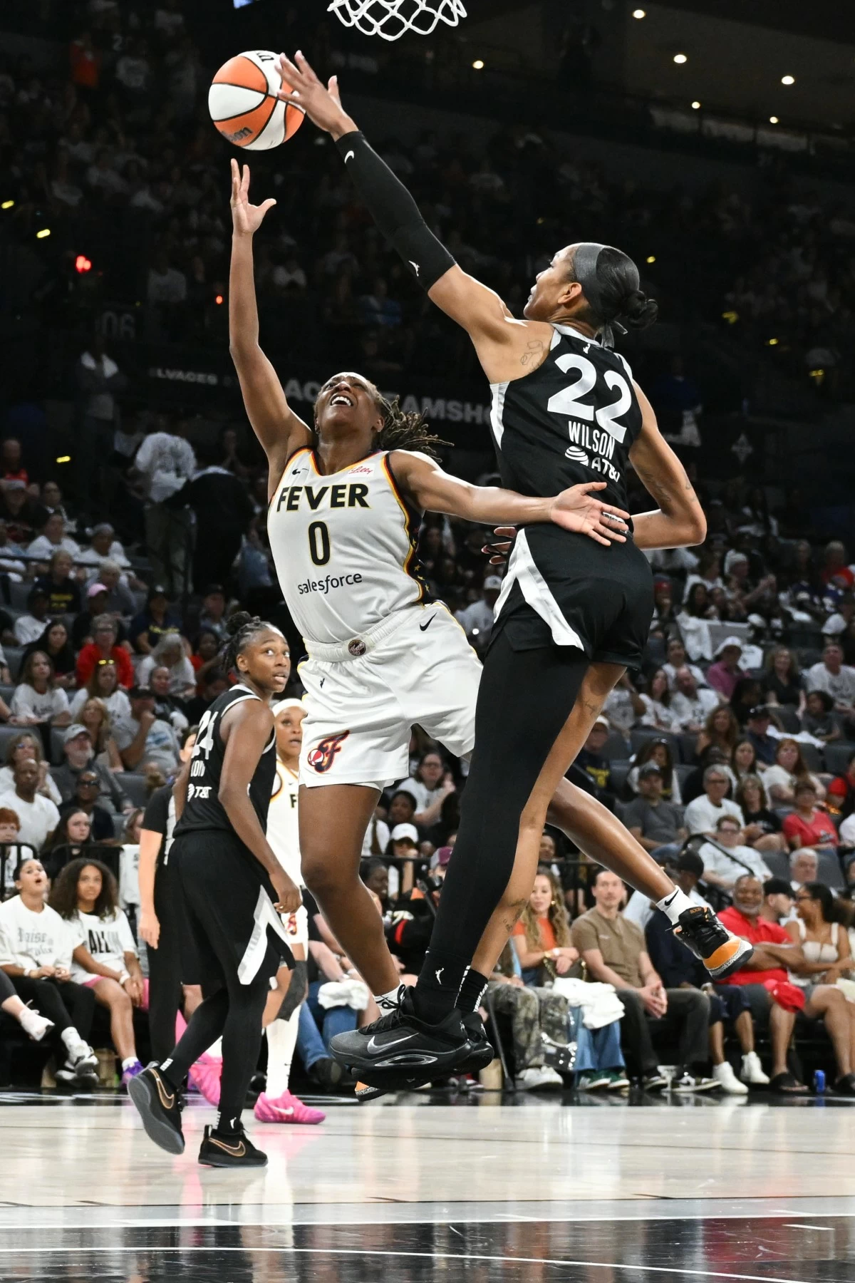 Indiana Fever guard Kelsey Mitchell (0) shoots against Las Vegas Aces center A'ja Wilson (22) in the second half of Game 1 of a WNBA basketball playoff semifinals series Sunday, Sept. 21, 2025, in Las Vegas. (AP Photo/Candice Ward)