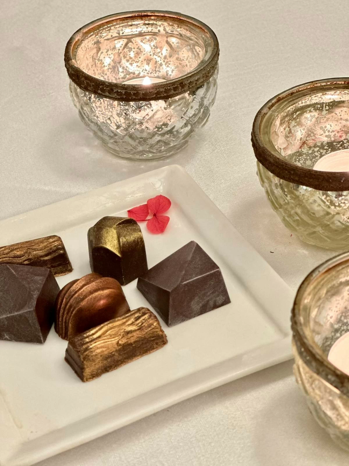 SWEET FINISH Handcrafted vegan chocolate pralines close the degustation menu, served alongside coffee or tea for a refined end to the meal
