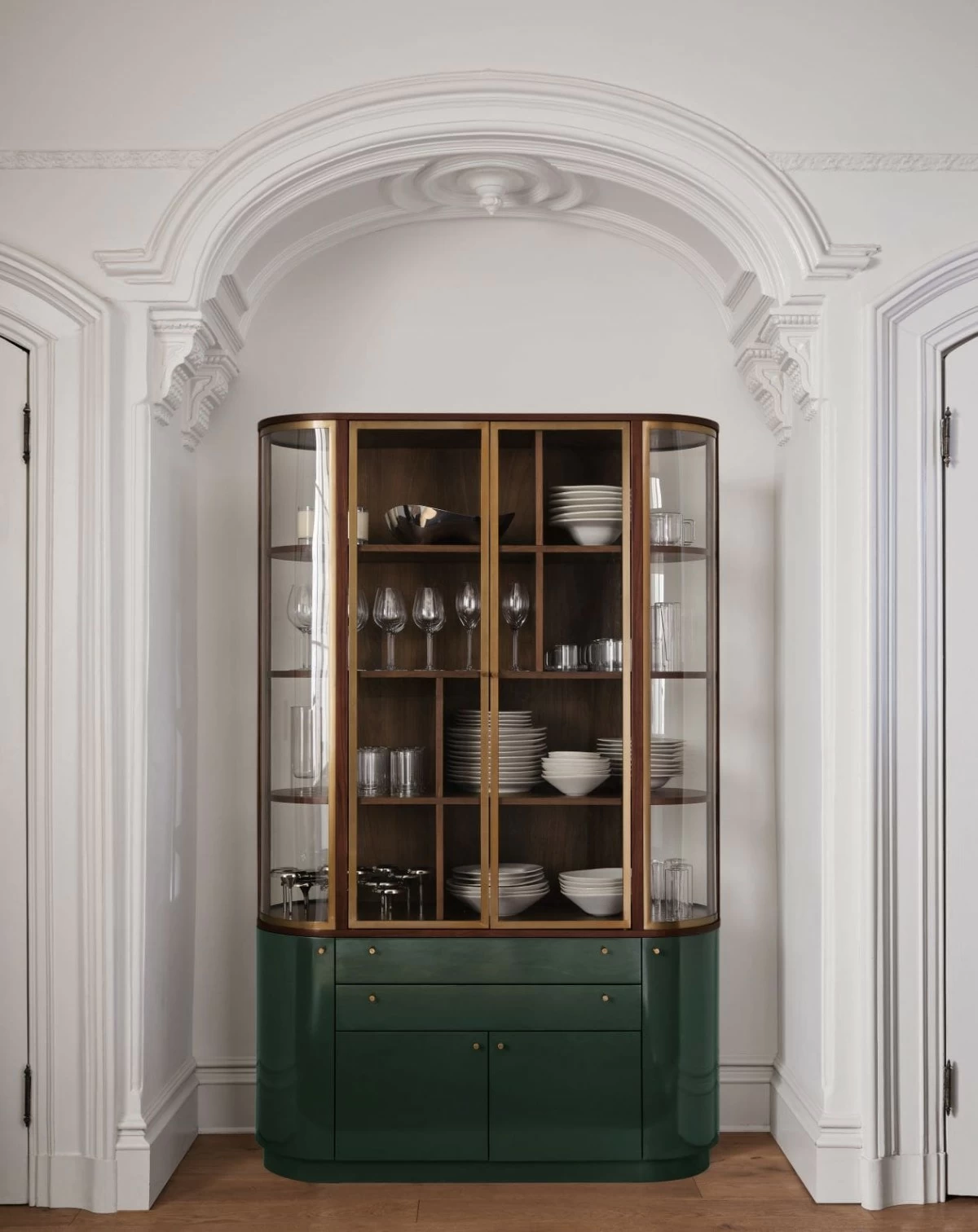 Grand, elegant and beautifully crafted, Zurich transcends mere functionality, becoming a sculptural centerpiece to house all your treasures. The cabinet captures attention with a unique racetrack silhouette formed by gracefully curved glass and a rounded green lacquer base.